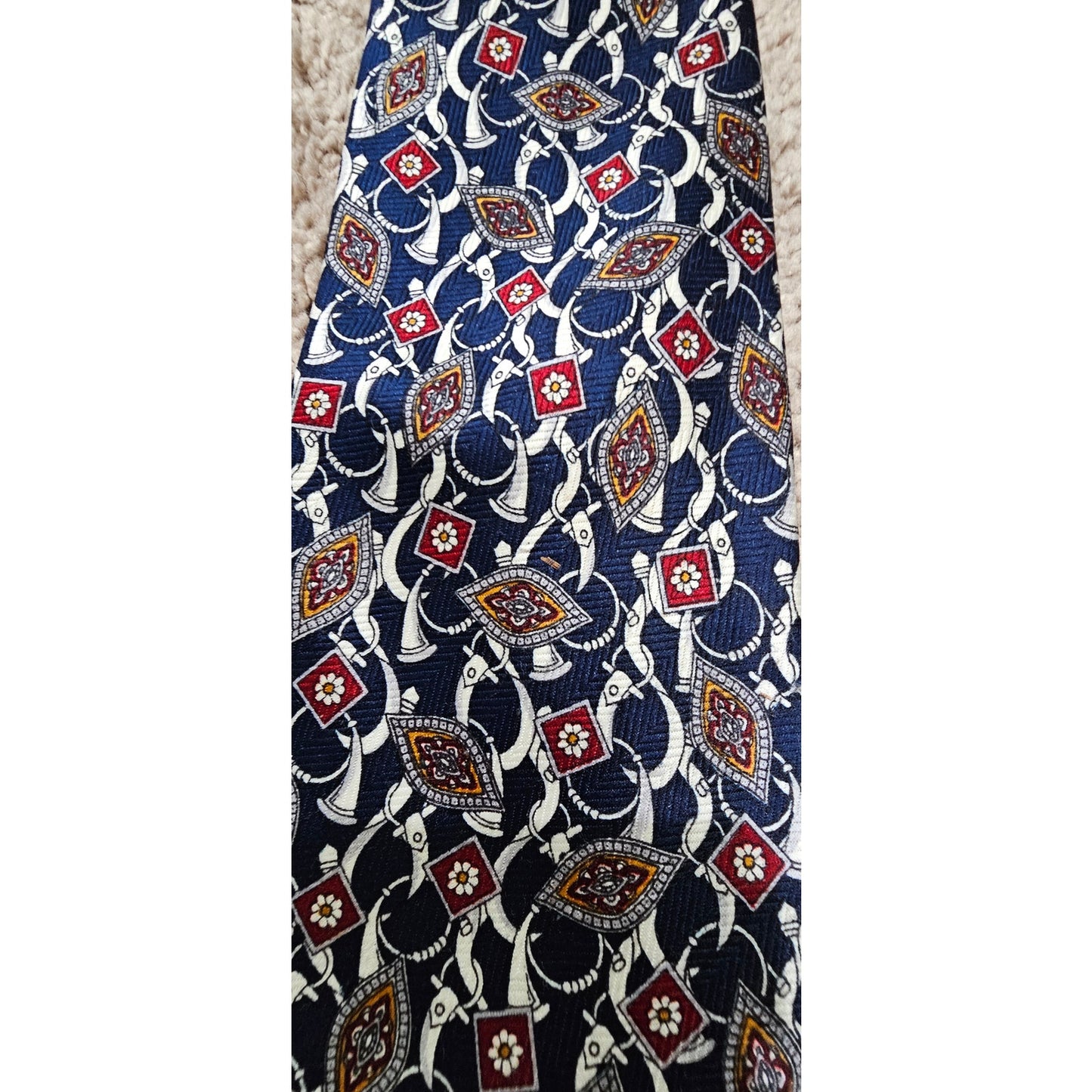Hermès silk tie with a classic geometric pattern in navy blue, red, and white tones