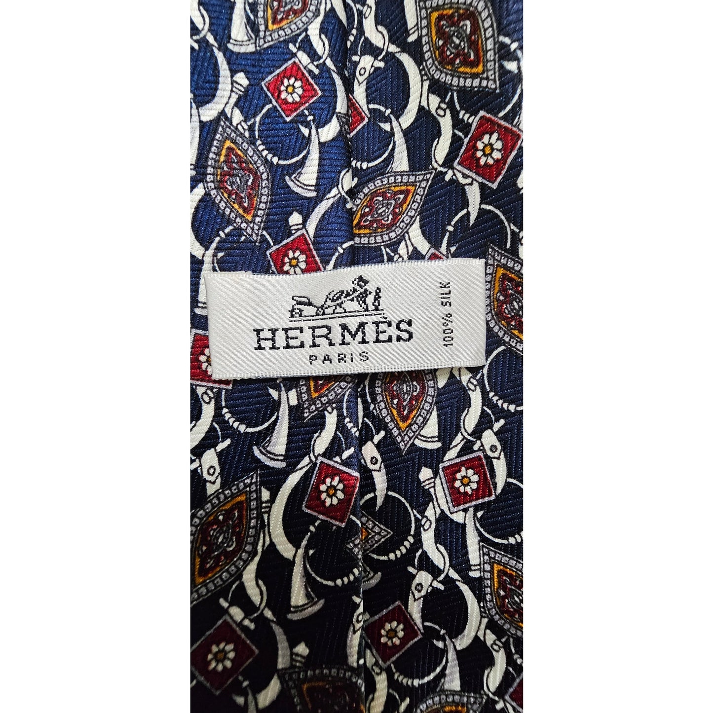 Hermès silk tie with a classic geometric pattern in navy blue, red, and white tones