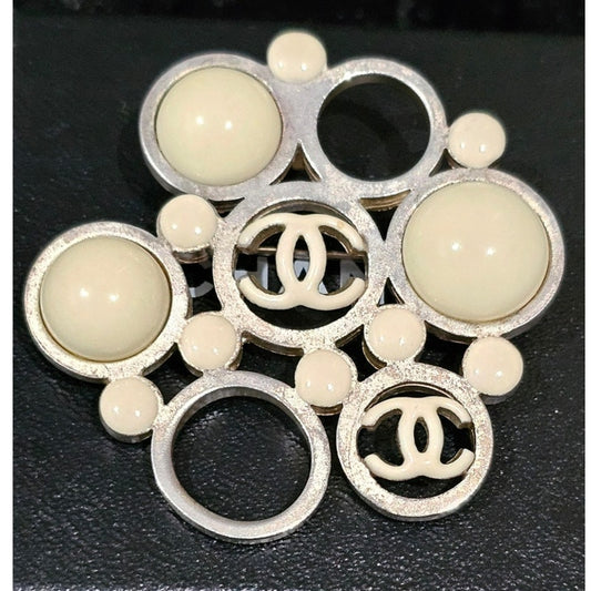 Vintage Chanel Metal Brooch with White Enamel CC Logos and Circular Detail